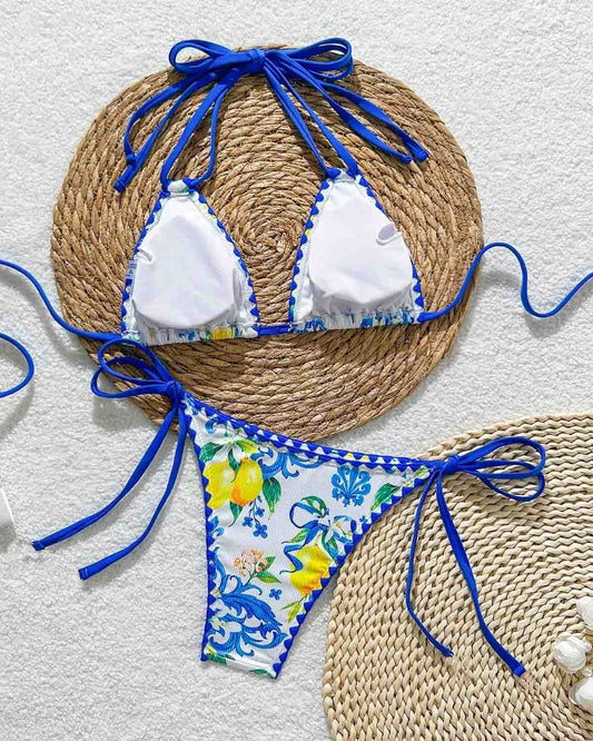 Bikini set with floral design and blue straps on a textured surface