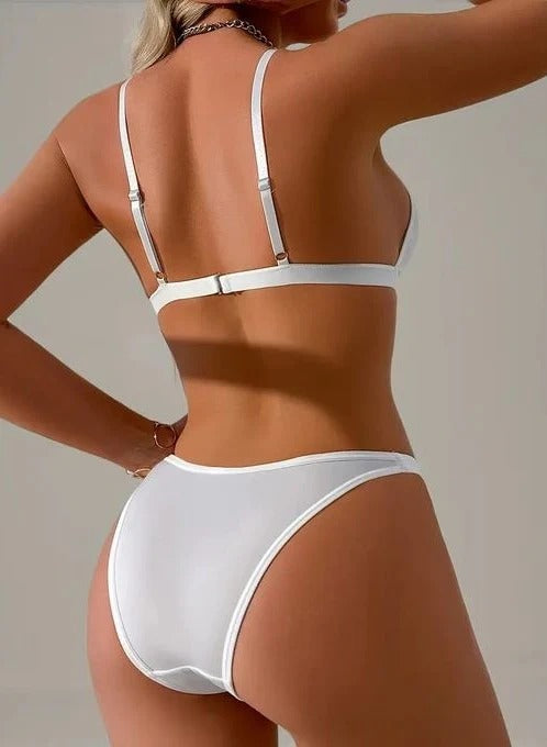 Person wearing a white bikini against a neutral background